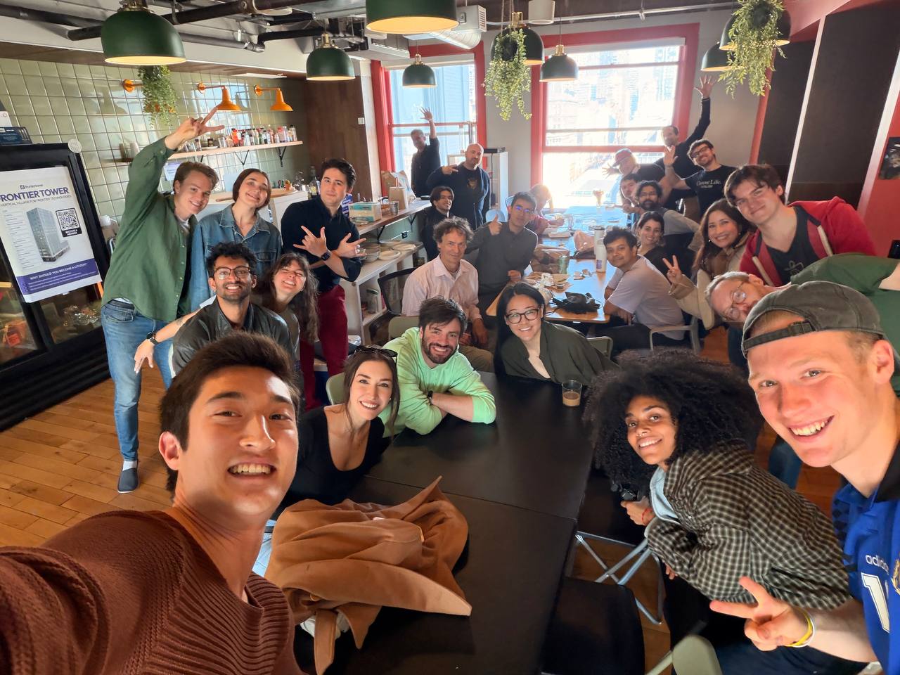 Huge group selfie of 20+ community members at a lunch gathering