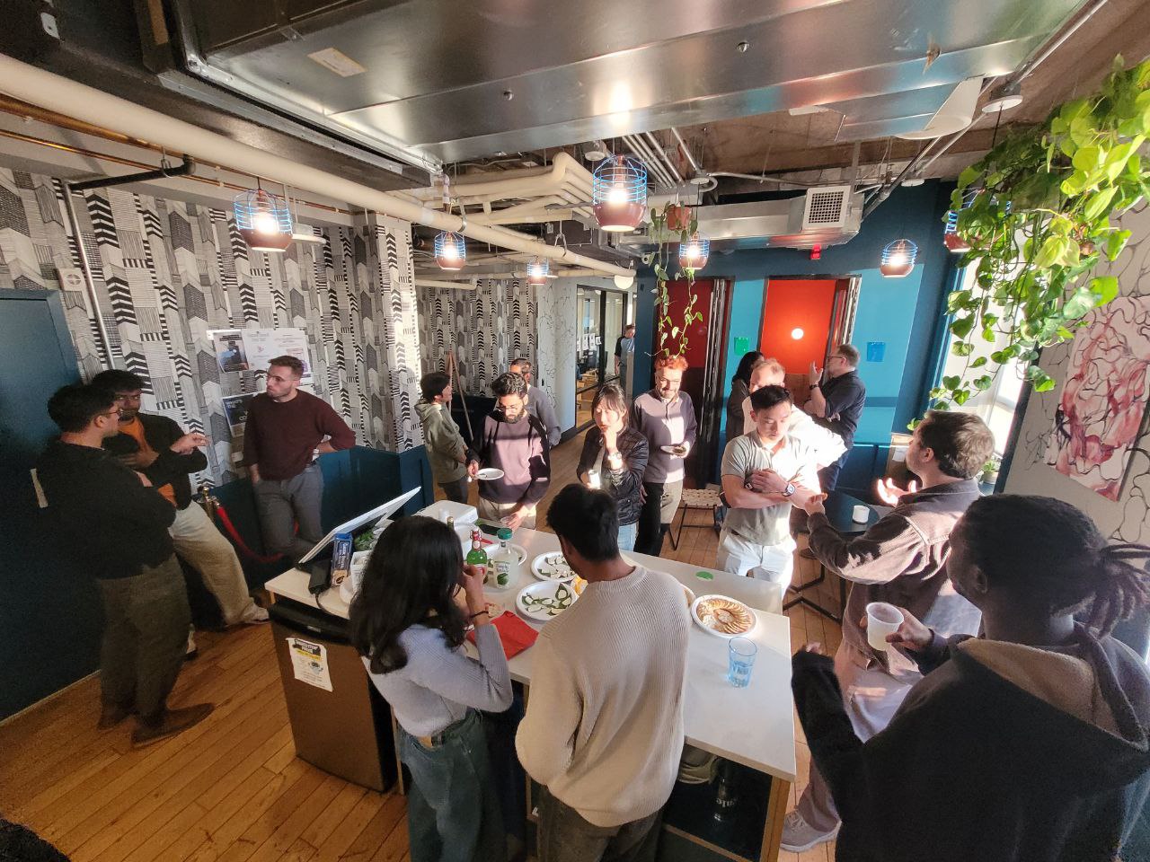 Networking mixer with people mingling and sharing food in a stylish lounge