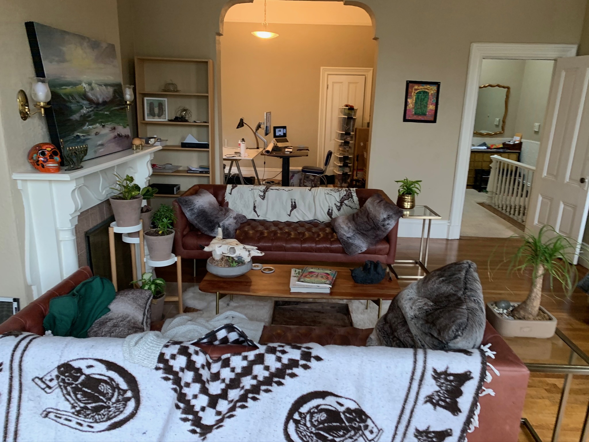 Living room with brown leather sofas, fireplace, and bohemian decor