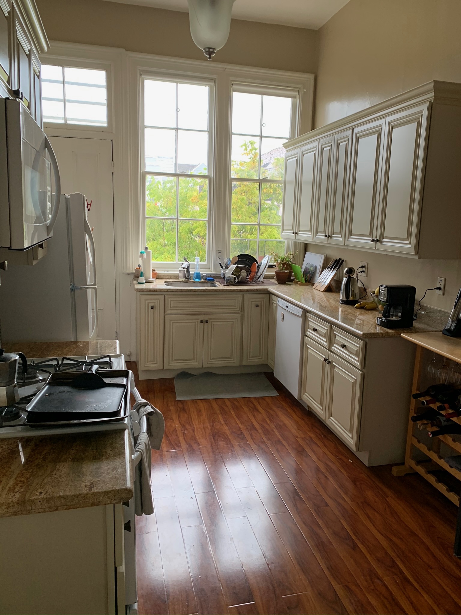 Kitchen with white cabinets, granite counters, and natural light
